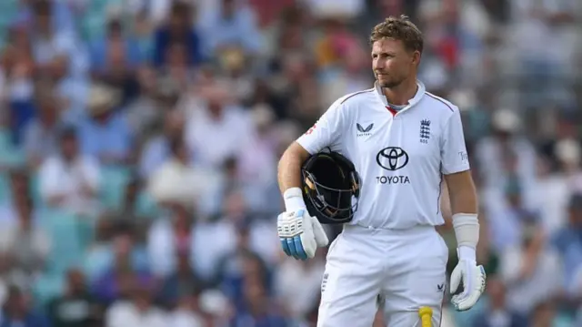 Joe Root, wearing whites, stand with his blue helmet tucked under his arm