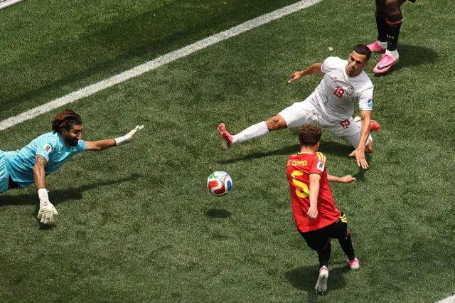 Alireza Beiranvand makes a save past Belgium's defender #05 Maxim De Cuyper