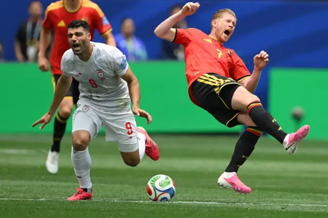 Iran's forward #09 Mehdi Taremi and Belgium's midfielder #07 Kevin De Bruyne fight for the ball