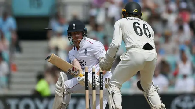 Jordan Cox, down on one knee, looks back at his stumps after being bowled, with Tom Blundell behind the stumps