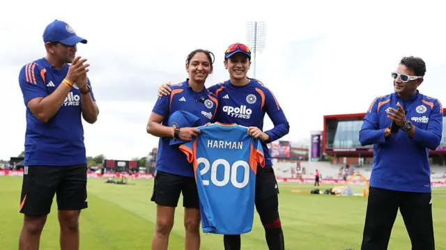 Harmanpreer Kaur (second left) holding a blue India shirt with Harman 200 written on the back