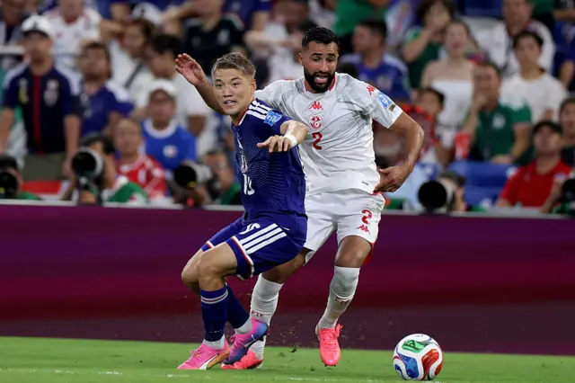 Ali Abdi (R) and Japan's midfielder #10 Ritsu Doan fight for the ball during the 2026 World Cup Group F football match between Tunisia and Japan