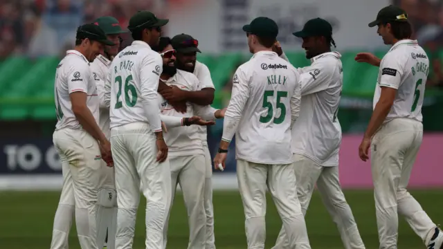 Leicestershire players huddle together to celebrate a Yorkshire wicket