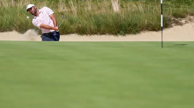 Scottie Scheffler chips out of the bunker