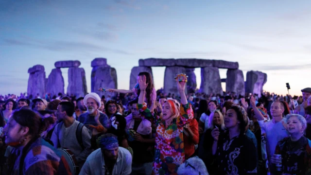 Crowds gather in front of Stonehenge for the sunrise.