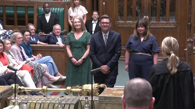 Andy Burnham smiles as he enters the House of Commons and walks through the centre of the chamber