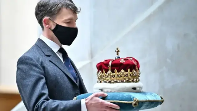 The Crown of Scotland being carried on a blue cushion