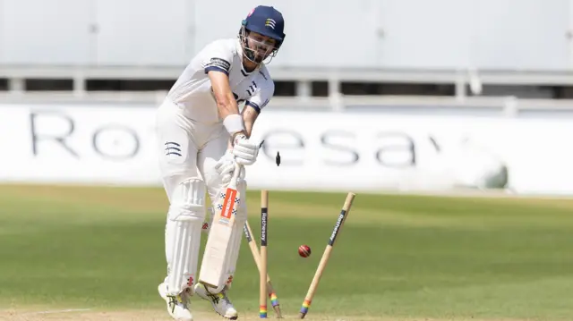Max Holden of Middlesex is bowled with two stumps out of the ground