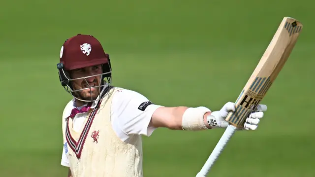 Craig Overton lifts his bat in acknowledgement