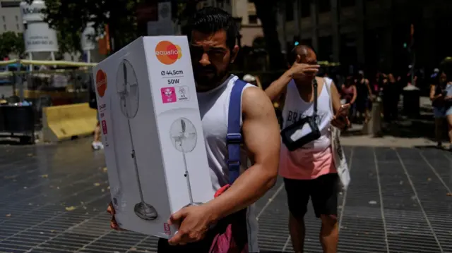 A man carries a newly purchased fan as temperatures rise, during a heatwave affecting a large part of Spain, in Barcelona, in Spain, June 21, 2026. REUTERS/Nacho Doce