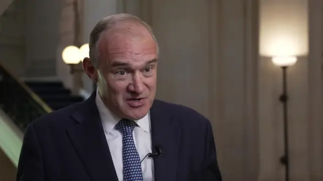 Ed Davey, pictured speaking to the camera, wearing a suit, shirt and tie