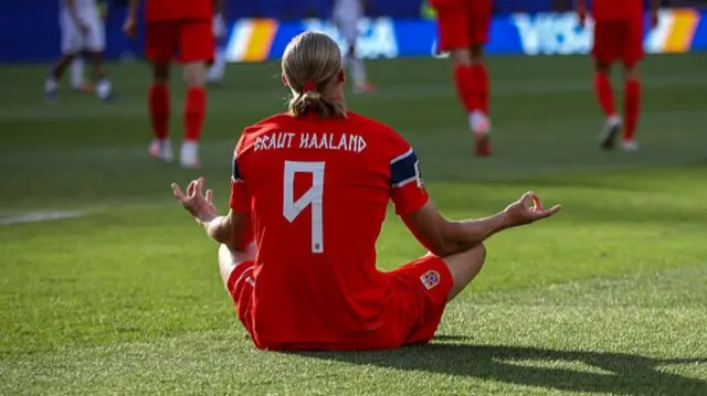 Erling Haaland sits cross legged in a zen pose with Braut-Haaland on the back of his shirt