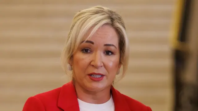 Mid shot of Michelle O'Neill, wearing red jacket. She has blonde hair which is tied up.