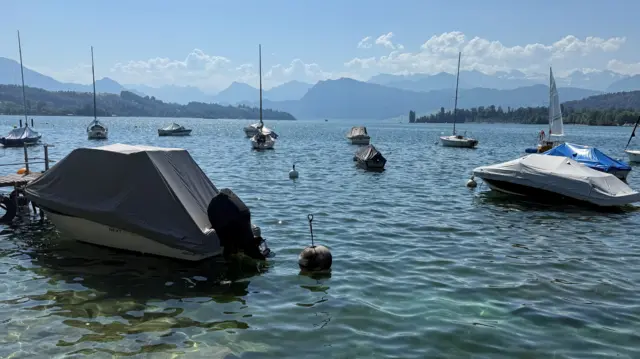 Lake Lucern in Switzerland, wiith mountains in the distance and boats in the water.