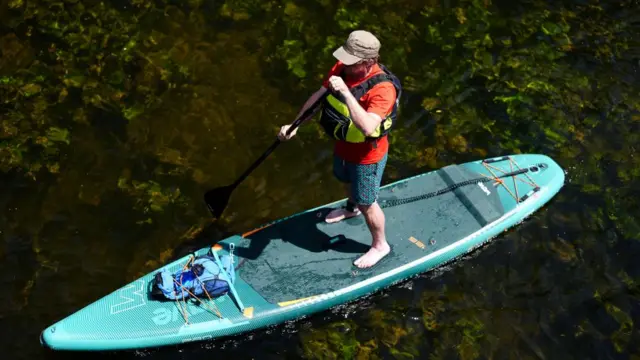 A man on a paddle board in Stratford-upon-Avon in Warwickshire.
