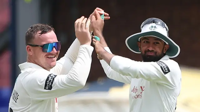 Liam Patterson-White does a high-five with Notts captain Haseeb Hameed