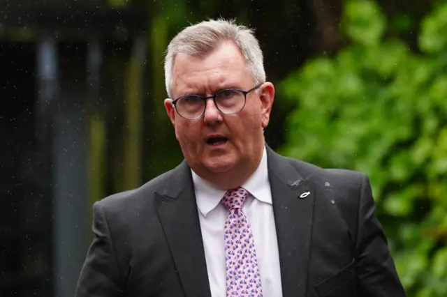 Jeffrey Donaldson departing Newry Crown Court. He is wearing a grey blazer, white shirt and pink tie