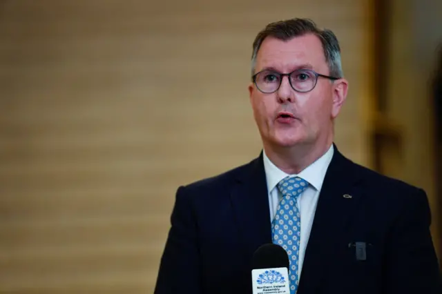 Donaldson standing at a microphone in Stormont't Great Hall