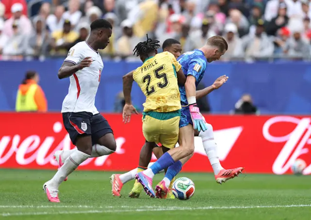 Jordan Pickford of England is challenged by Prince Adu