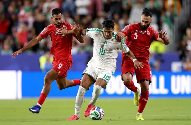 Fares Chaibi #10 of Algeria controls the ball against Ali Olwan #9 and Yazan Alarab #5 of Jordan during the FIFA World Cup 2026 Group J match between Jordan and Algeria