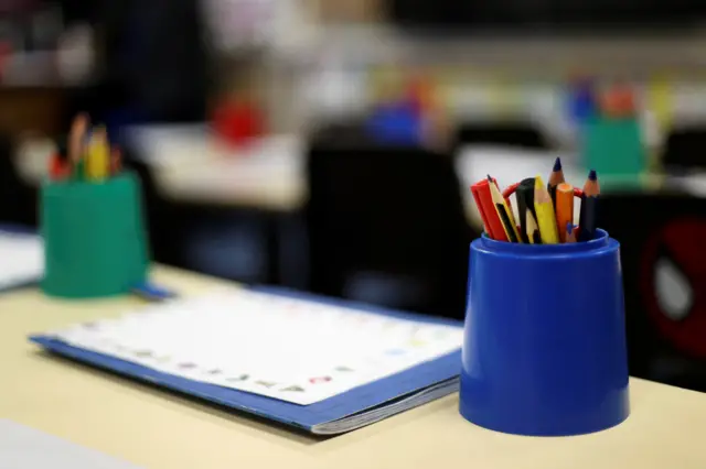 Pencil pots on desks in school