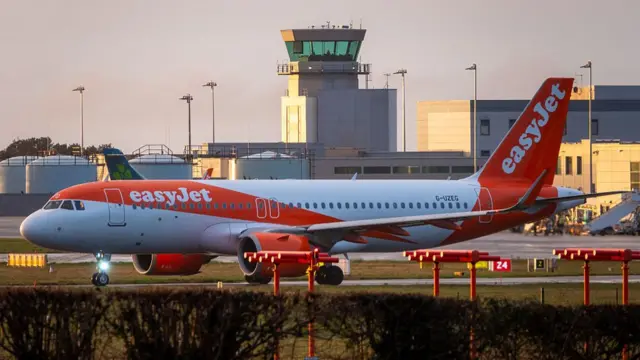 A EasyJet aircraft taxis along the runway at Bristol Airport during sunrise