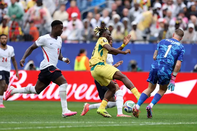Jordan Pickford #1 of England is challenged by Prince Adu