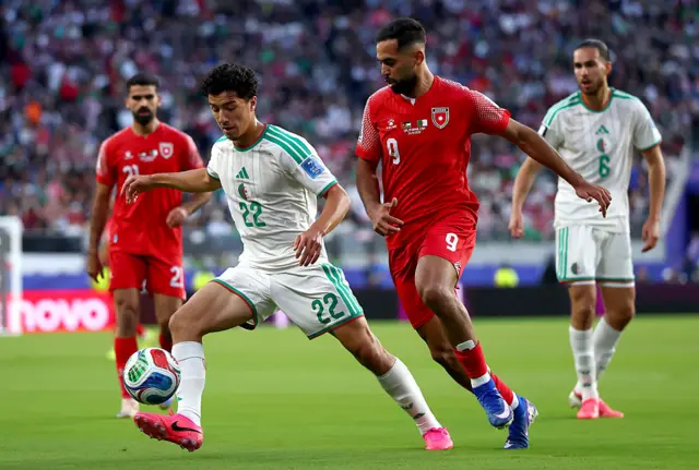 Ibrahim Maza #22 of Algeria controls the ball under pressure from Ali Olwan #9 of Jordan during the FIFA World Cup 2026 Group J match between Jordan and Algeria