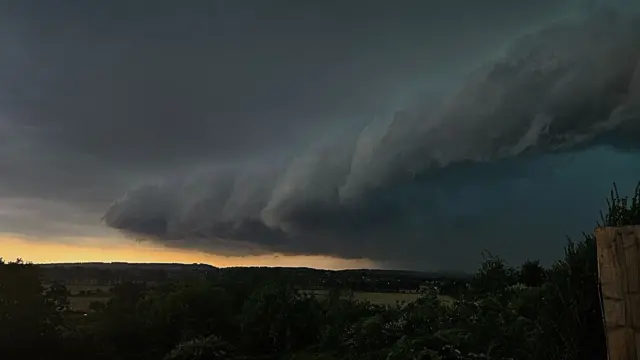 A huge billowing dark cloud approaching a town.