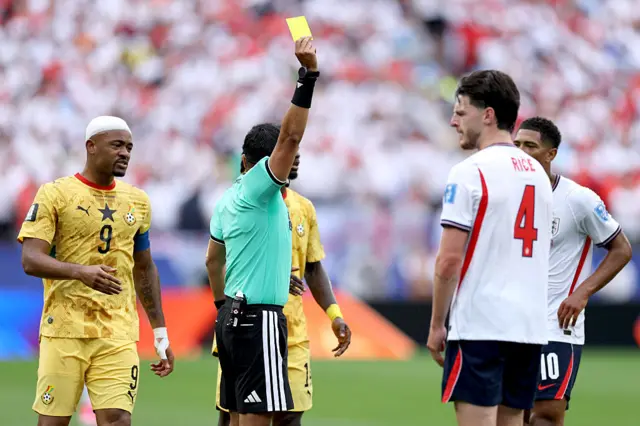 Referee Said Martinez shows a yellow card to Declan Rice