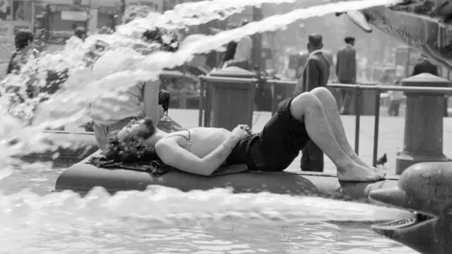 Trafalgar Square, London, 8th June 1976. People use fountains to keep cool.