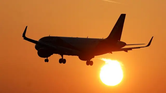 An EasyJet plane coming in to land at London Gatwick Airport as the sun rises over Crawley, West Sussex.