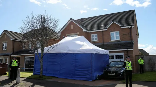 blue tent outside house with police