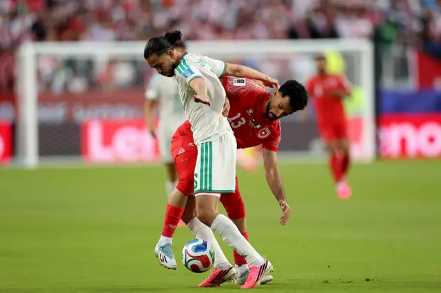 Ramiz Zerrouki #6 of Algeria is challenged by Mahmoud Almardi #13 of Jordan during the FIFA World Cup 2026 Group J match between Jordan and Algeria