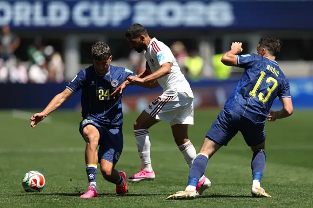 Hassan Alhaydos of Qatar competes for the ball against Nidal Celik