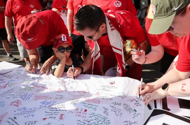 Fans sign a banner in tribute to Canada's Ismael Kone who was injured during his last match