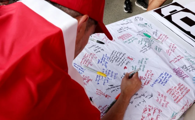 Fans sign a banner in tribute to Canada's Ismael Kone who was injured during his last match