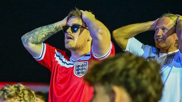 England fans react as their team fail to score while attending at Newquay FC's stadium in Cornwall to watch a large screen broadcast on the pitch on June 23, 2026 in Newquay, England.