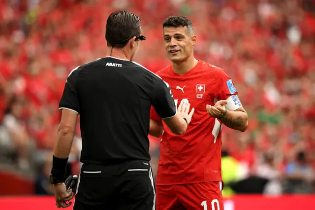 Granit Xhaka of Switzerland protests to Referee Ramon Abatti