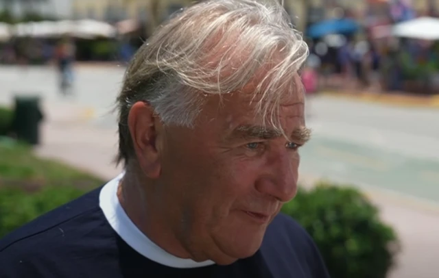 an older man with fair hair wearing a Scotland top