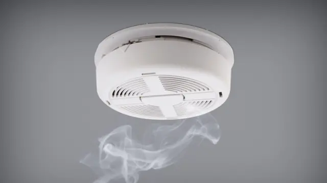 A smoke alarm with smoke underneath