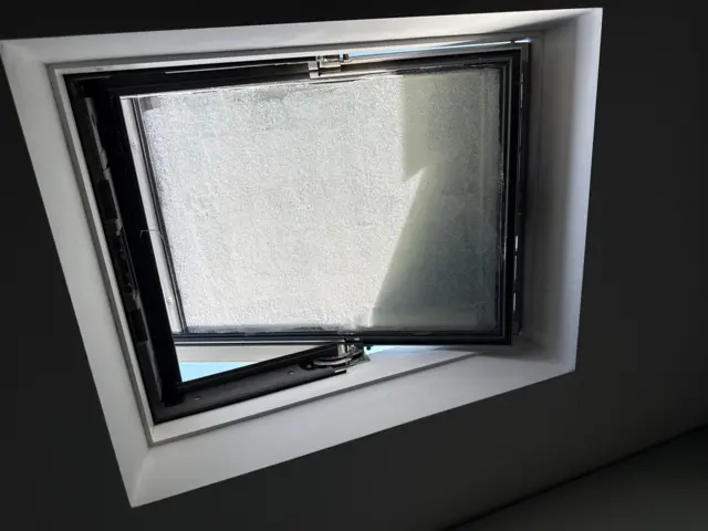 A view of a window inside Emma's home. The sun is gleaning on to the window, which is covered in yoghurt
