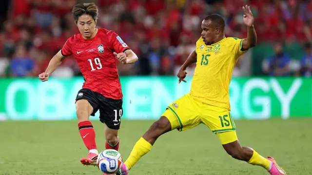 Kang-In Lee of Korea Republic competes for the ball against Iqraam Rayners #15 of South Africa during the FIFA World Cup 2026 Group A match between South Africa and Korea Republic.