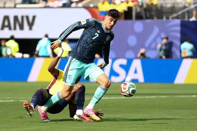 Kai Havertz (R) falls past Ecuador's defender #04 Joel Ordonez