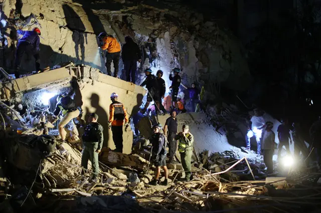 First responders attend a damaged building at Los Palos Grandes