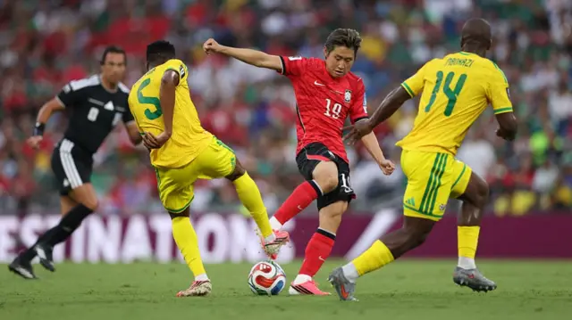 Kang-In Lee #19 of Korea Republic controls the ball against Thalente Mbatha #5 and Mbekezeli Mbokazi #14 of South Africa during the FIFA World Cup 2026 Group A match between South Africa and Korea Republic.