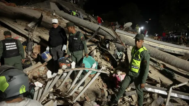 Emergency services work at the site of a collapsed building after an earthquake in Venezuela