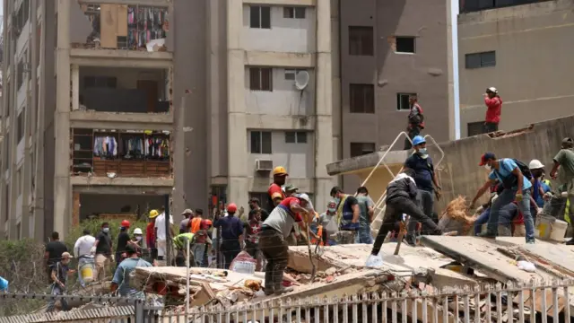 People search for casualties amid the rubble of a collapsed building in Caracas