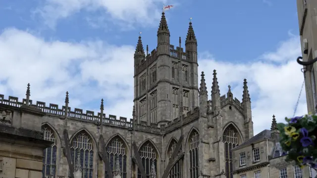 Bath Abbey shown from a short distance, with the camera pointing up towards the grand tower.
