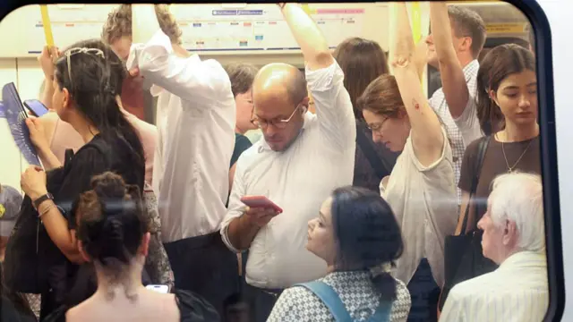 Commuters travel on a London Underground tube carriage, during a heatwave.